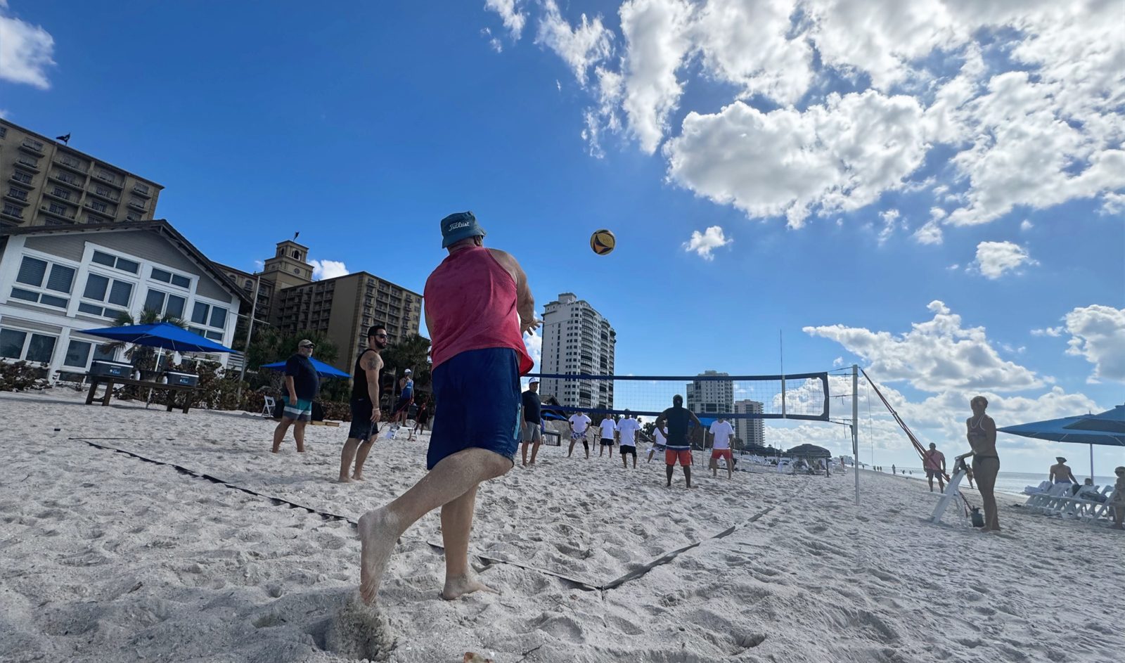 Multiple beach volleyball courts set up for a group event in Naples