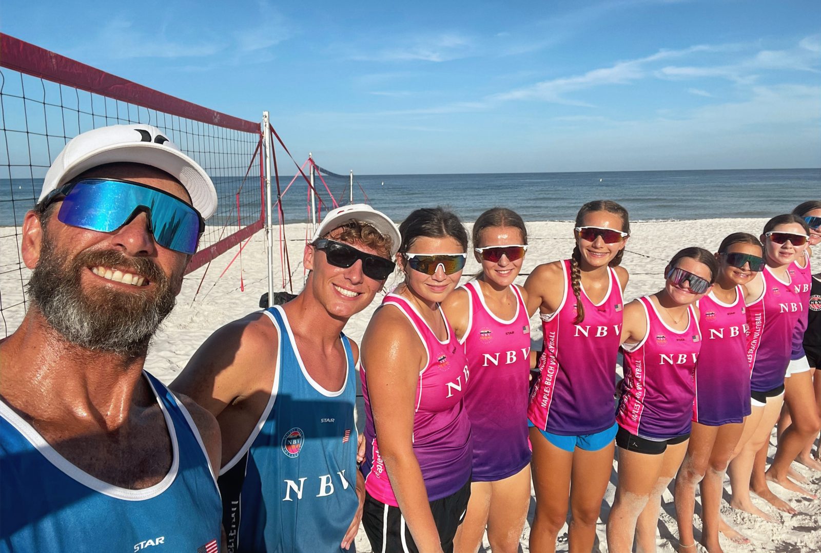 Coach and NBV junior girls team at a beach volleyball tournament