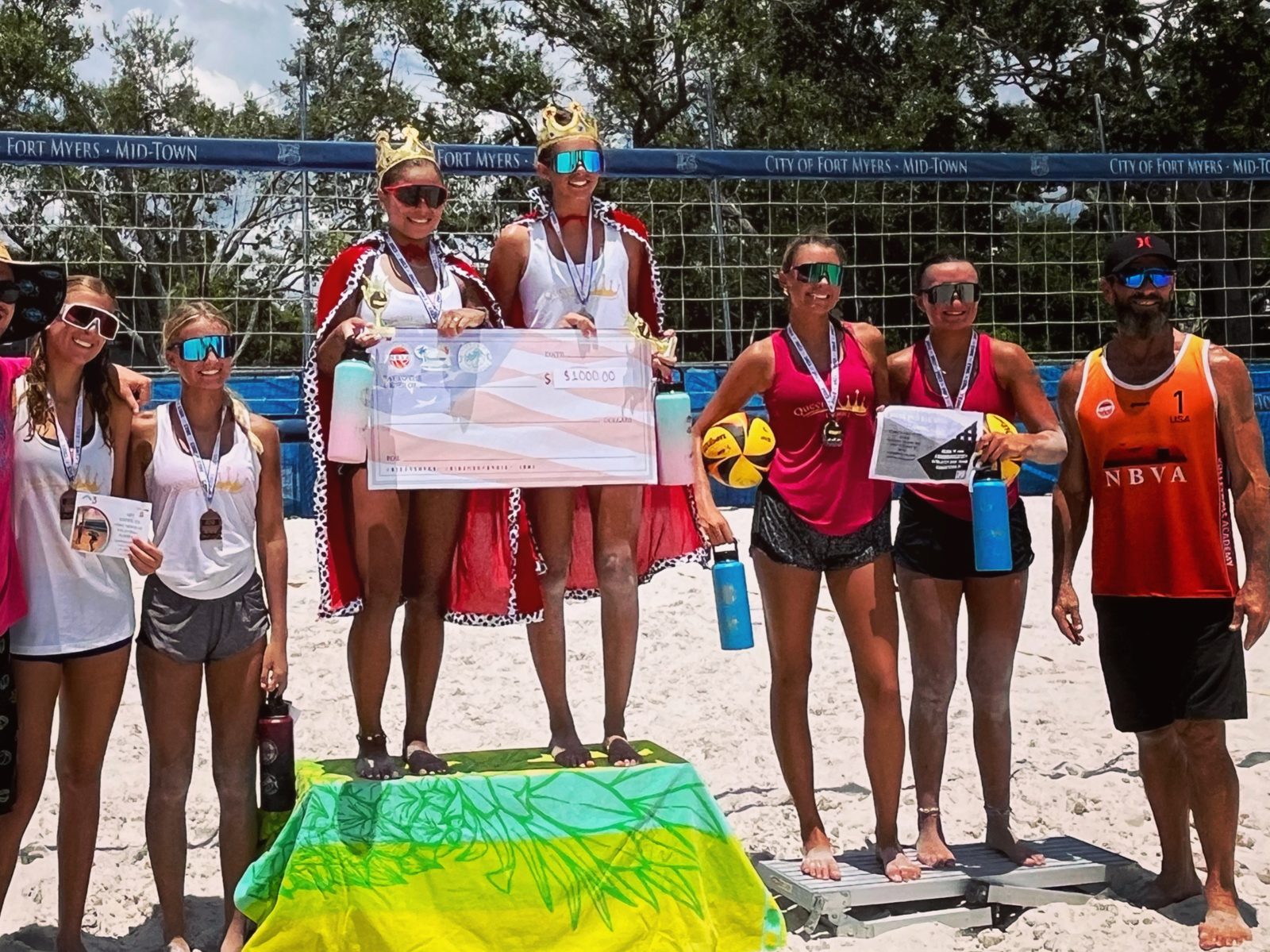 Junior athletes on the podium with medals after a beach tournament
